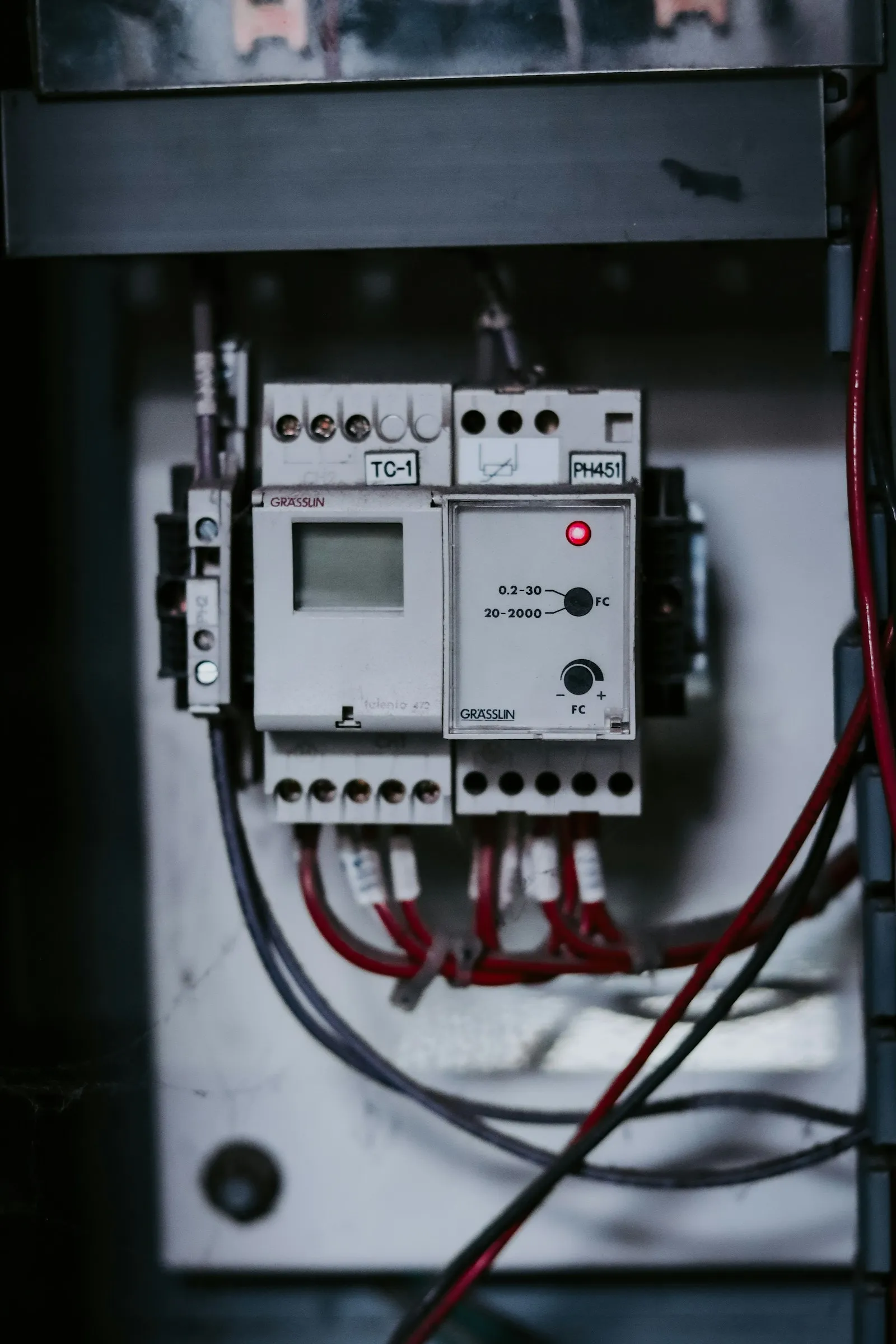 A close-up of DIN-rail-mounted timer and relay modules wired in a control panel.