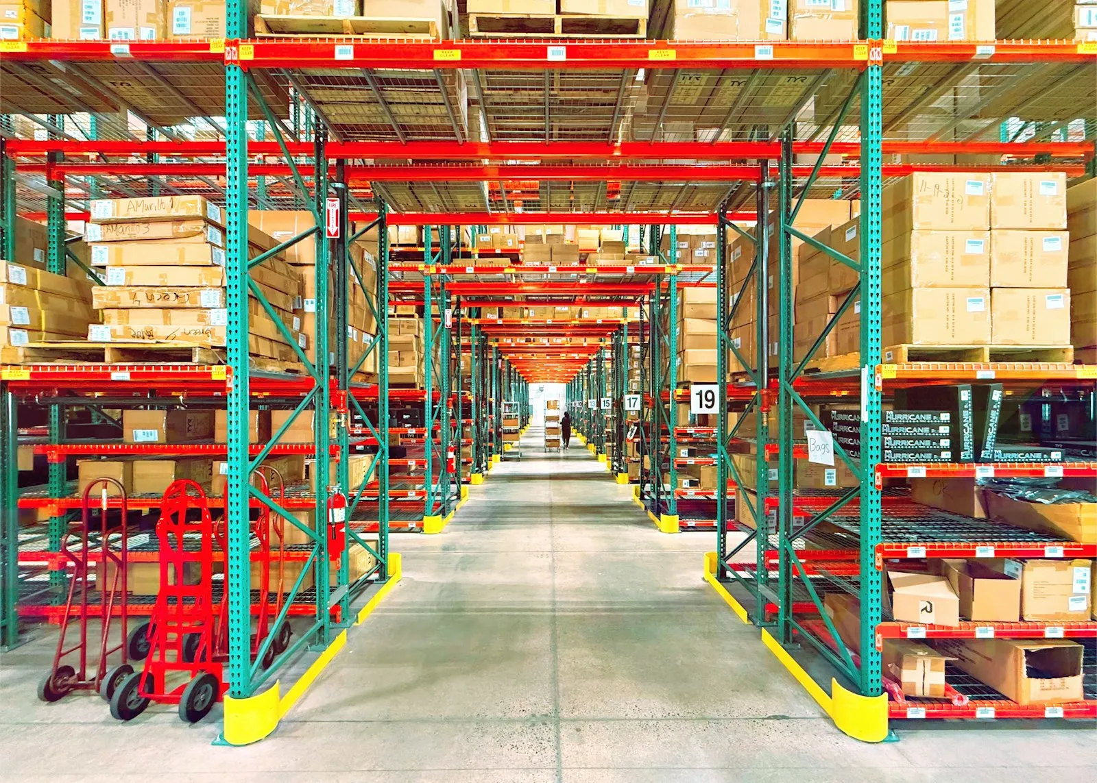 A US distribution-warehouse aisle lined with racking and boxed inventory.
