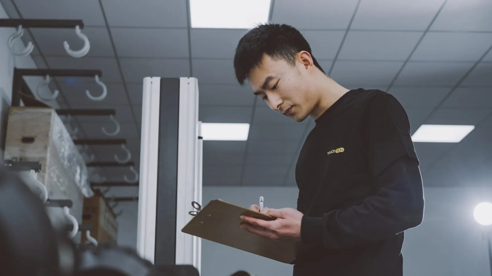 An inspector checking goods against a clipboard in a warehouse.